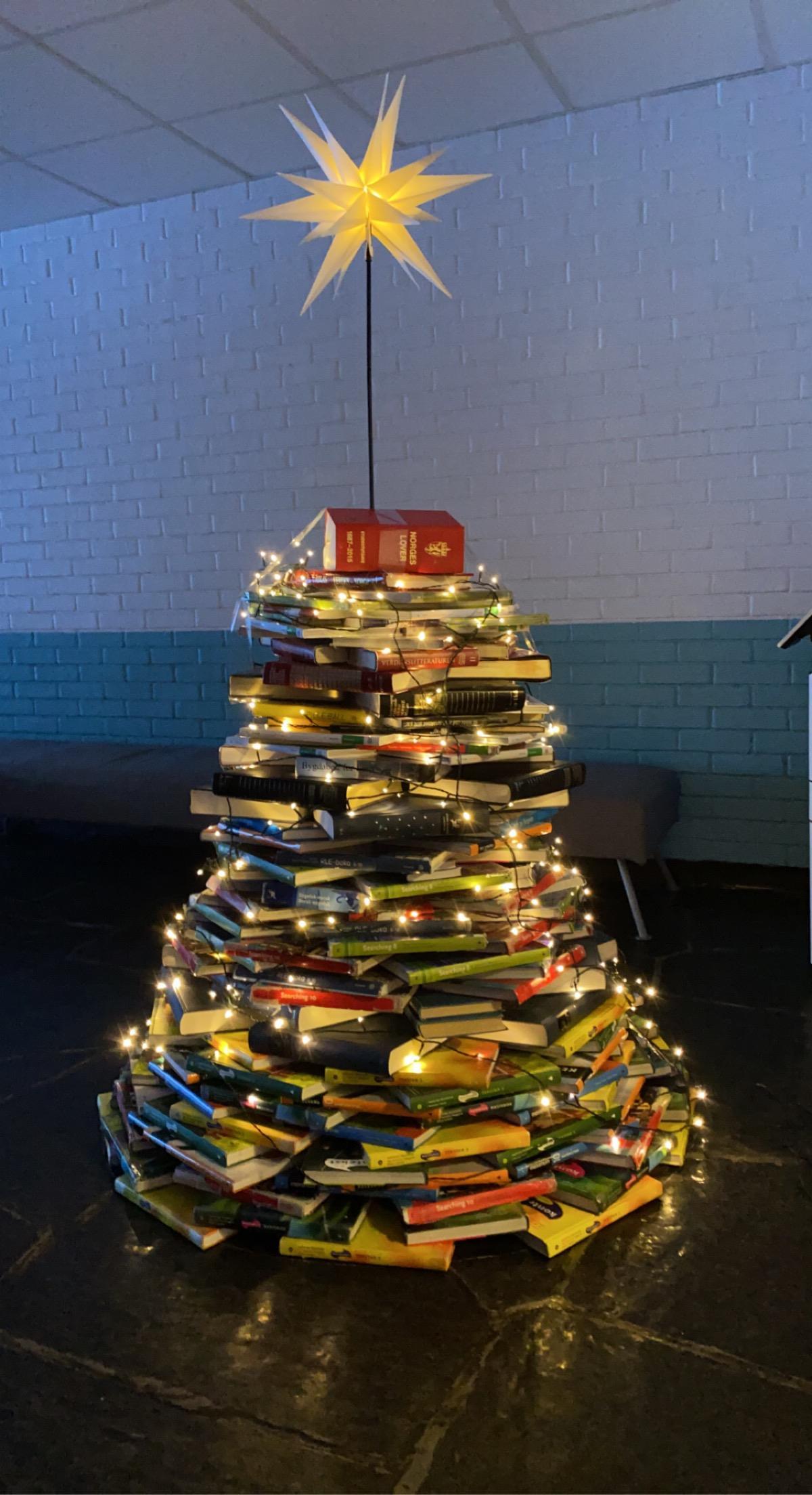 Eit juletre laga av bøker med stjerne og juletreljos. - Klikk for stort bilde